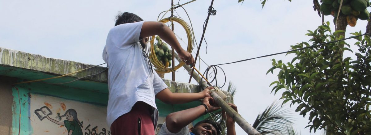 Two volunteers fixing a freedombox antenna